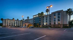 Hollywood Hotel multi-story exterior with parking lot and palm trees at dusk